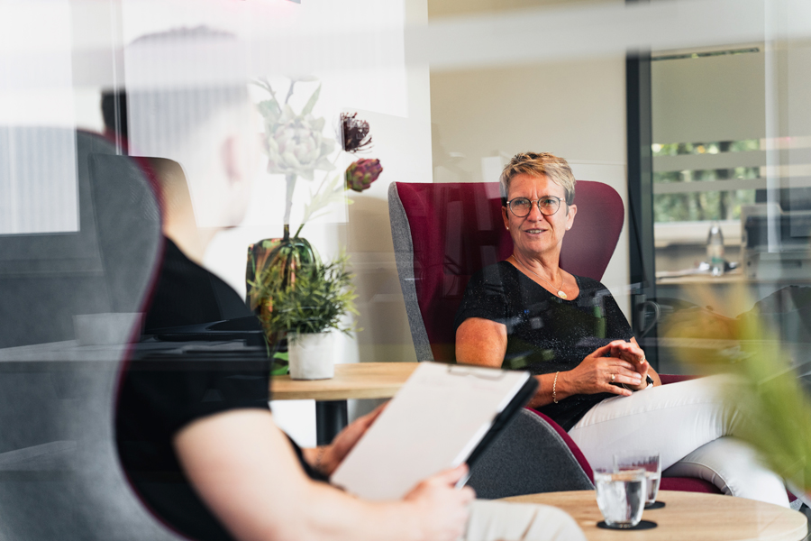 Petra Hering bespricht sich mit einem Kollegen der Albert GmbH & Co. KG. Beide sitzen in einem Ohrensessel in angenehmer Atmosphäre